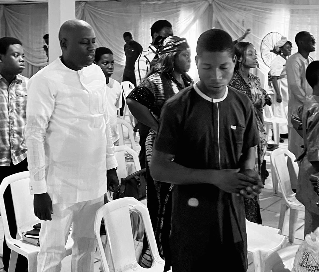 The congregation of New Hope Baptist Church standing in prayer